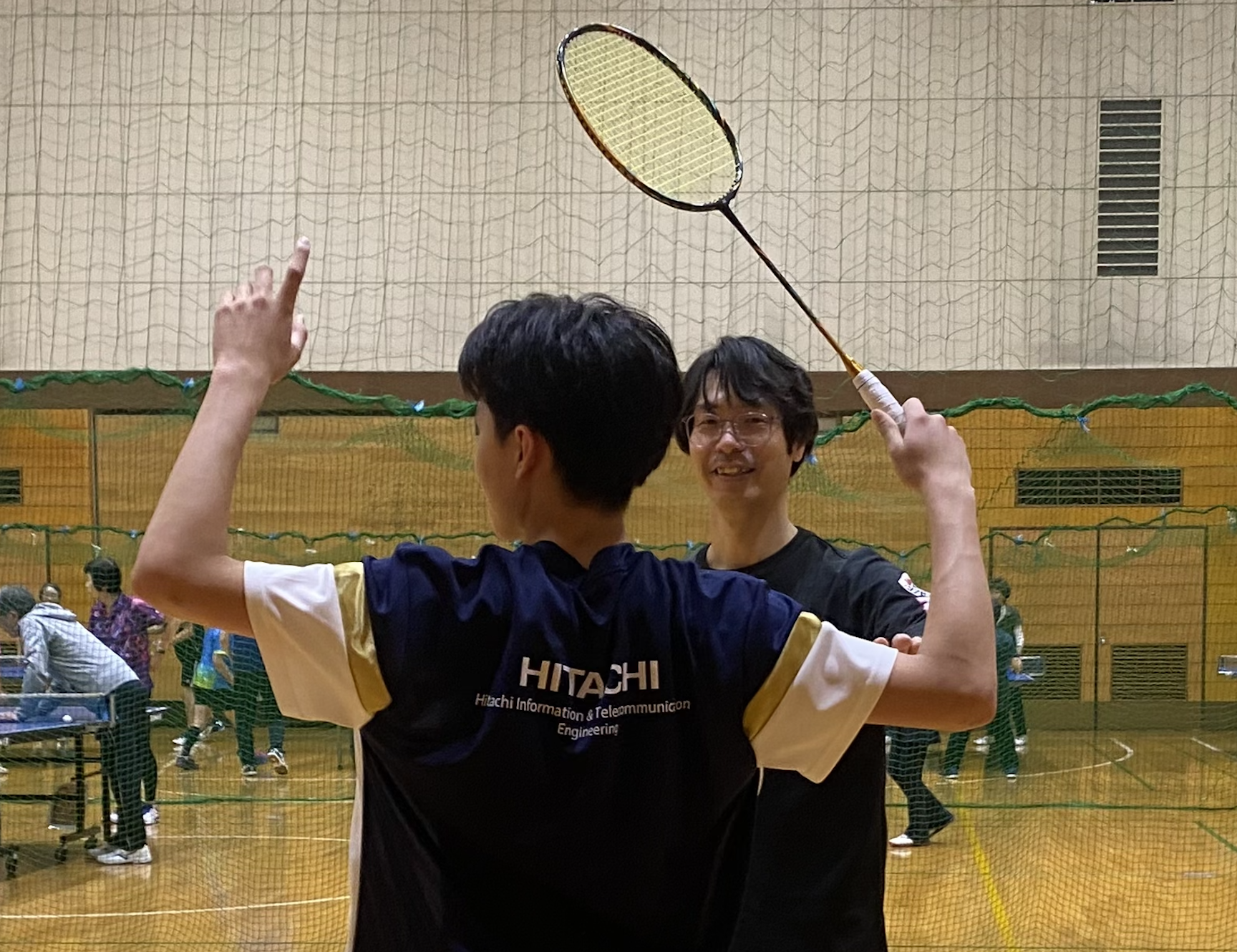 ジュニアのバドミントン練習について保護者がコーチに相談している様子